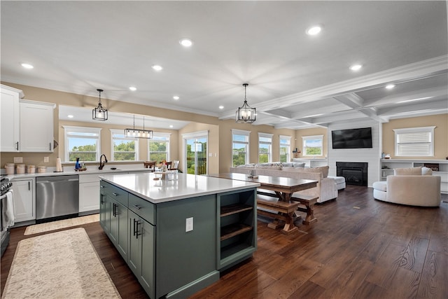 kitchen with a large fireplace, a kitchen island, dark wood-type flooring, dishwasher, and white cabinetry