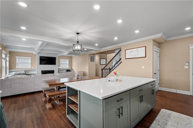 kitchen with gray cabinetry, a center island, dark hardwood / wood-style flooring, decorative light fixtures, and a fireplace