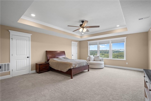 carpeted bedroom featuring ceiling fan, ornamental molding, and a tray ceiling