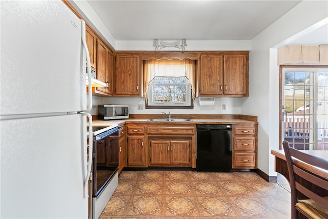 kitchen with white appliances, sink, and a healthy amount of sunlight