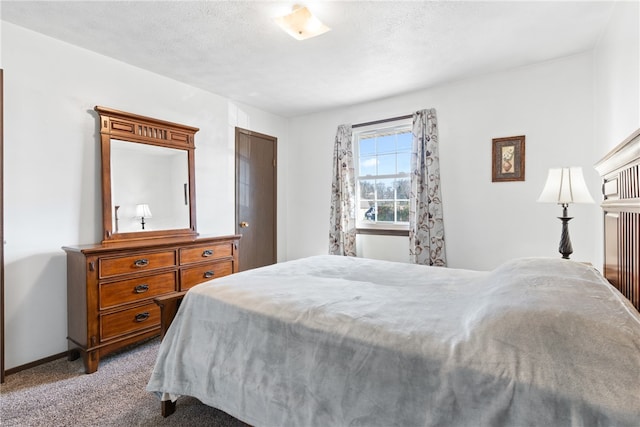 bedroom with light colored carpet and a textured ceiling