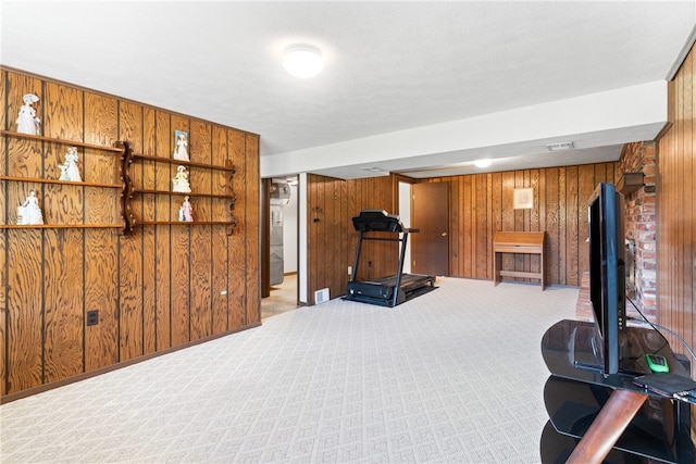 exercise room featuring wood walls and light carpet