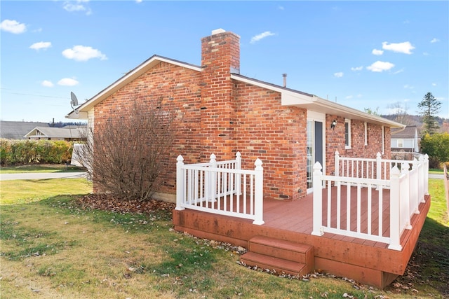 view of property exterior featuring a wooden deck and a yard