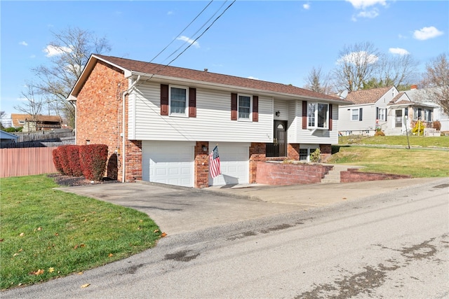 raised ranch with a front lawn and a garage