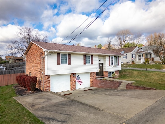 bi-level home featuring a garage and a front yard