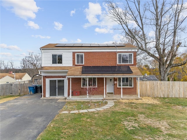 view of front of property featuring solar panels and a front yard