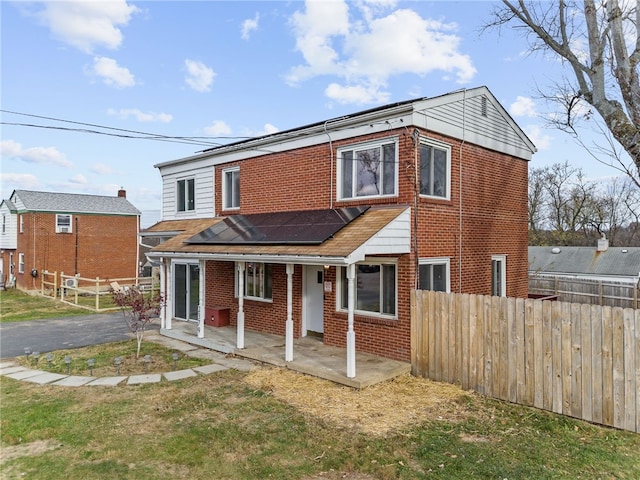 view of front of property with solar panels and a patio