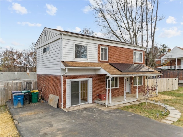 rear view of property featuring solar panels