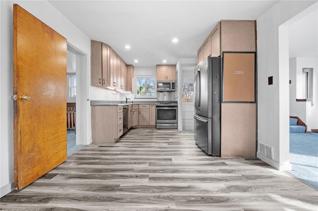 kitchen featuring light wood-type flooring, light brown cabinetry, and appliances with stainless steel finishes