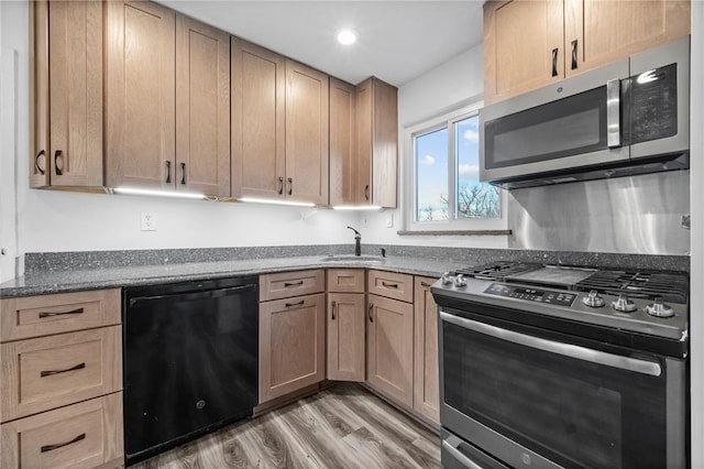 kitchen featuring hardwood / wood-style flooring, light brown cabinetry, sink, and appliances with stainless steel finishes