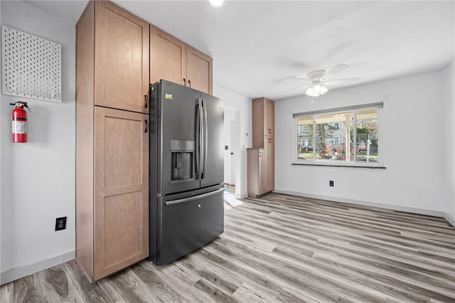 kitchen featuring ceiling fan, stainless steel fridge, and light wood-type flooring