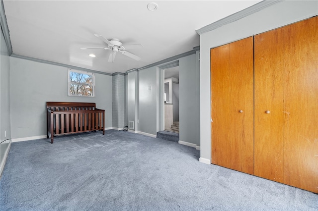 unfurnished bedroom with carpet floors, a closet, ornamental molding, and ceiling fan