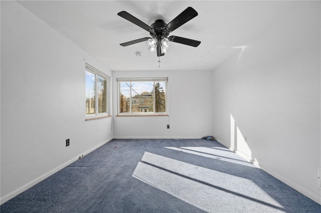 empty room featuring dark colored carpet and ceiling fan