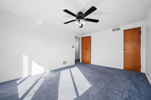 unfurnished room with ceiling fan and dark carpet