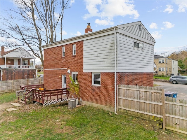 back of house with a yard, a deck, and cooling unit