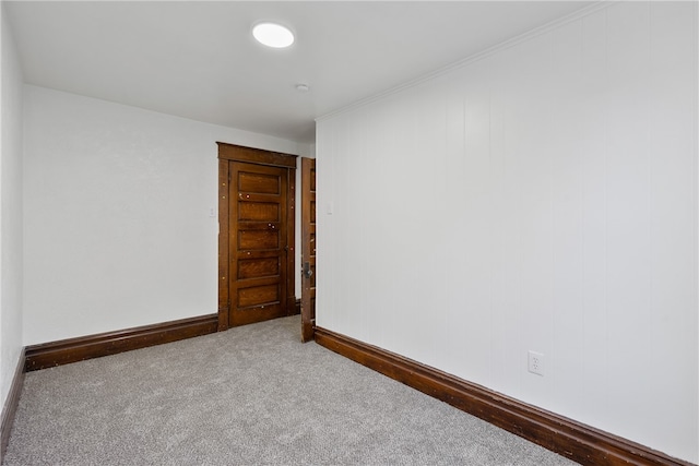 spare room with ornamental molding and carpet