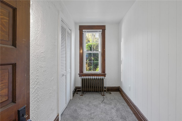 interior space featuring radiator, wooden walls, and carpet floors