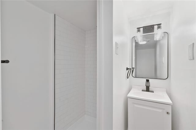 bathroom featuring vanity and tiled shower