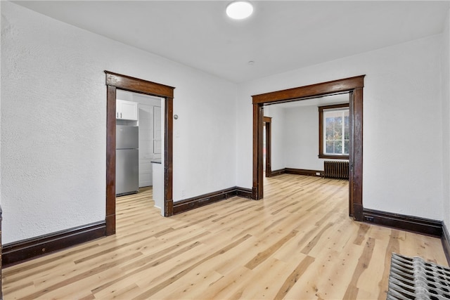 empty room with radiator and light hardwood / wood-style floors