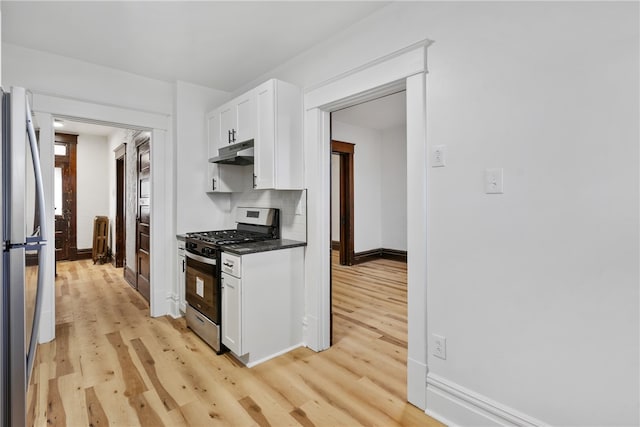 kitchen featuring stainless steel appliances, light hardwood / wood-style floors, white cabinetry, and backsplash