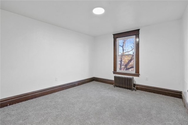 empty room featuring carpet and radiator heating unit