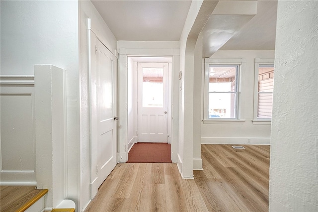 hall featuring plenty of natural light and light hardwood / wood-style flooring