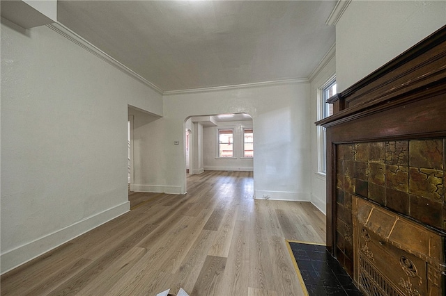 unfurnished living room featuring light wood-type flooring and ornamental molding