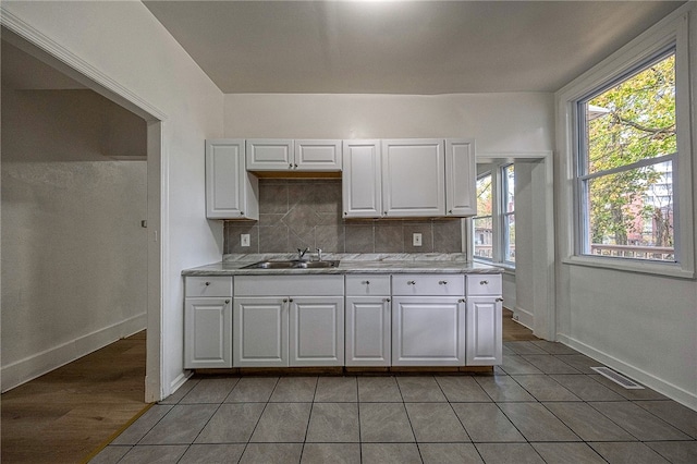 kitchen with white cabinets, decorative backsplash, a healthy amount of sunlight, and sink