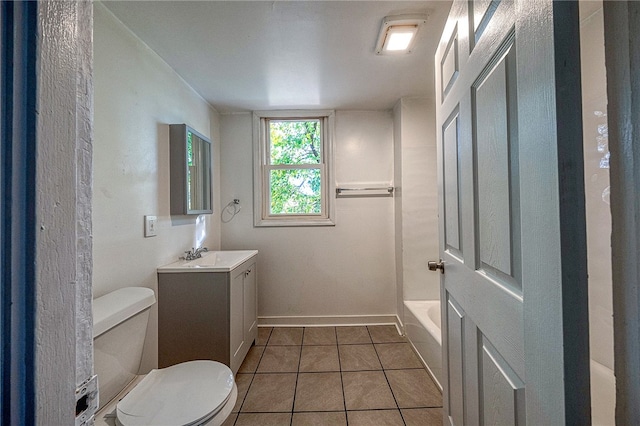 bathroom with toilet, a bath, vanity, and tile patterned floors