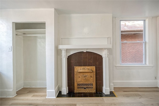 details with hardwood / wood-style flooring and a tile fireplace