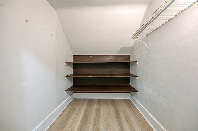 staircase with lofted ceiling and hardwood / wood-style flooring