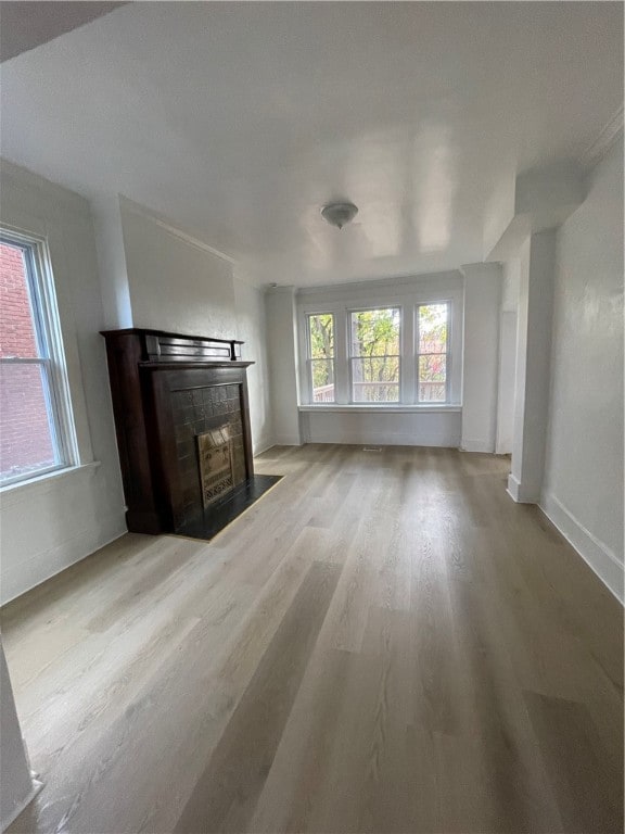 unfurnished living room with a fireplace and light hardwood / wood-style floors