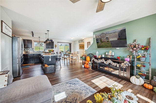 living room with dark wood-type flooring, sink, and ceiling fan