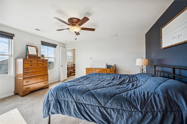 carpeted bedroom with multiple windows and ceiling fan