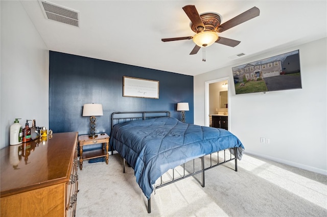 carpeted bedroom featuring ceiling fan and ensuite bath