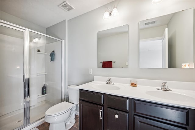 bathroom featuring hardwood / wood-style floors, a shower with shower door, vanity, and toilet