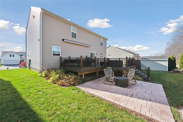 rear view of house featuring a wooden deck, a yard, and a patio area