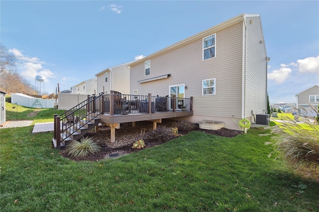 rear view of house with central AC, a yard, and a deck