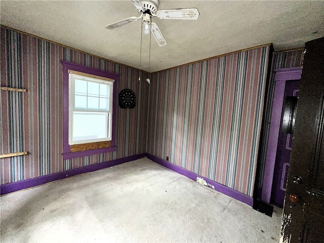 spare room with ceiling fan, light colored carpet, and a textured ceiling