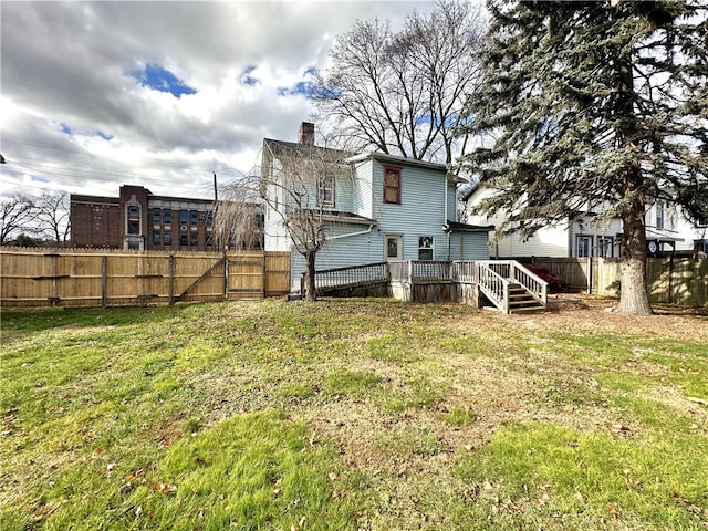 back of property with a lawn and a wooden deck