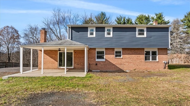 rear view of house with ceiling fan, a yard, and a patio area