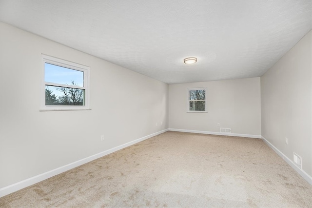 carpeted empty room with plenty of natural light