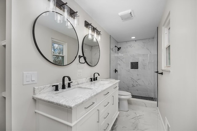 bathroom featuring toilet, vanity, and a tile shower