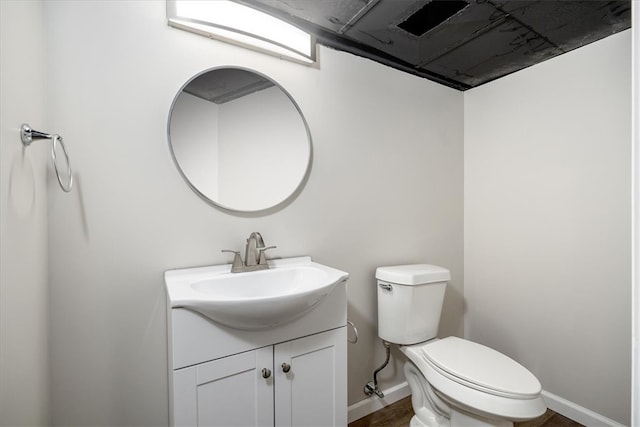 bathroom with hardwood / wood-style flooring, vanity, and toilet