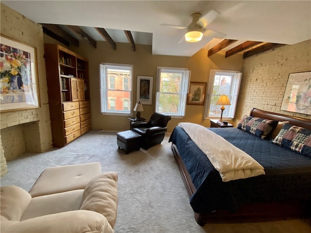 bedroom with a ceiling fan, carpet, a fireplace, and beamed ceiling