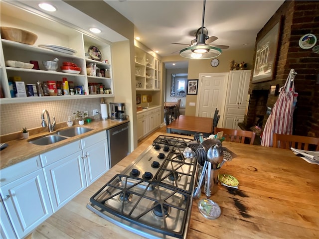 kitchen with open shelves, stainless steel appliances, light countertops, a sink, and ceiling fan