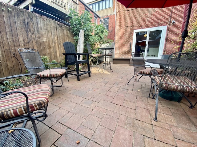 view of patio with outdoor dining space and fence