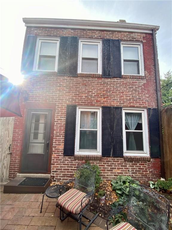 view of front of house featuring fence and brick siding