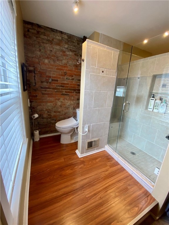 bathroom with visible vents, a shower stall, toilet, and wood finished floors