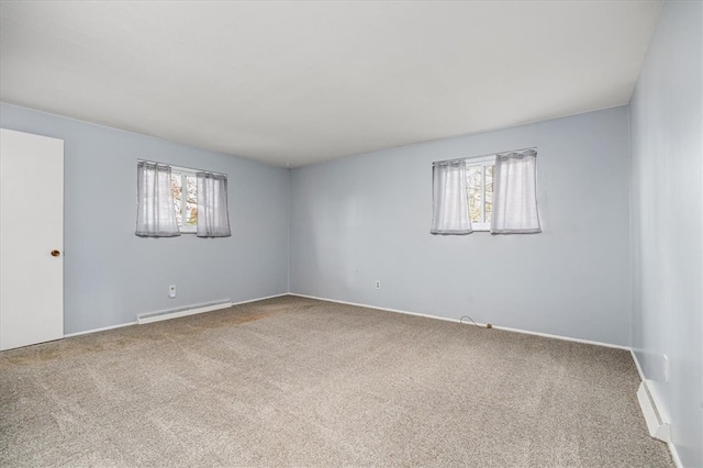 carpeted empty room with baseboard heating